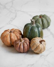 Artificial mini pumpkins on marble counter