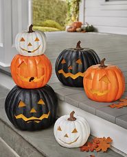 Assorted stackable artificial Jack-o’-Lanterns on porch steps