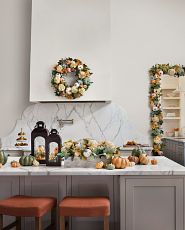 Kitchen island decorated with pumpkins, autumn foliage, and lanterns